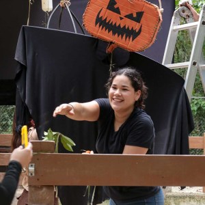 Smiling person decorates with Halloween pumpkin lanterns.